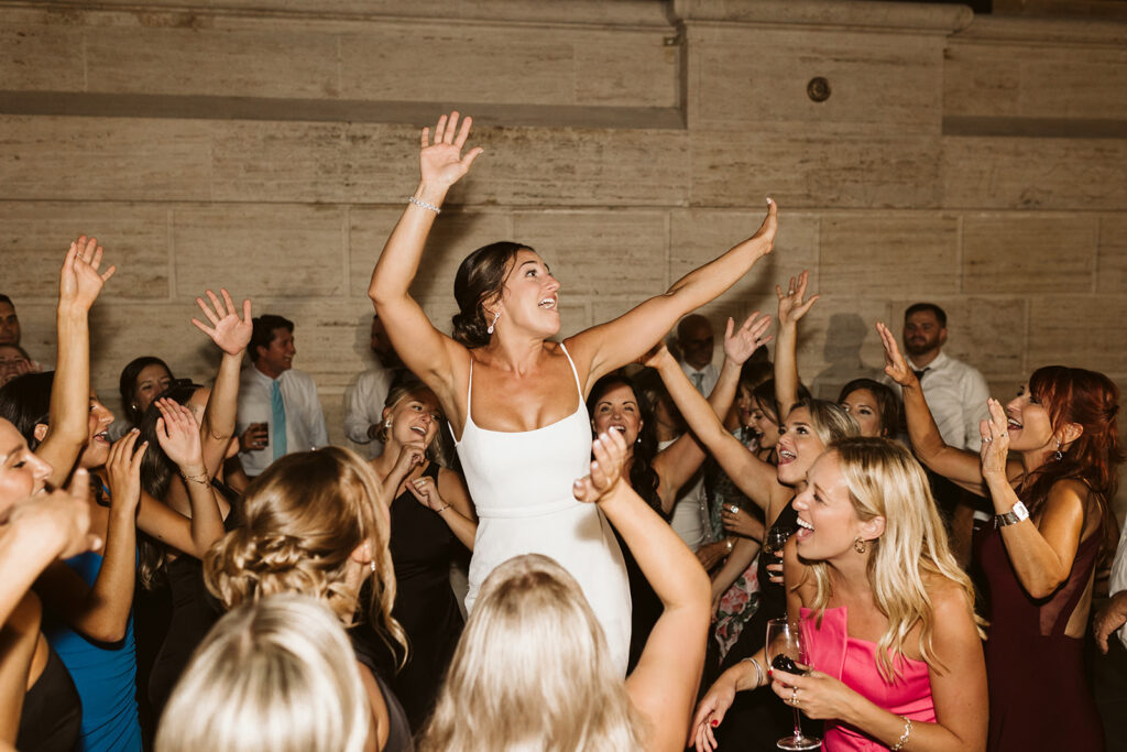 Bride dancing on the dance floor surrounded by cheering wedding guests